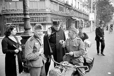 Des soldats de l'armée allemande discutent avec un policier français  Source : ECPAD, droits réservés